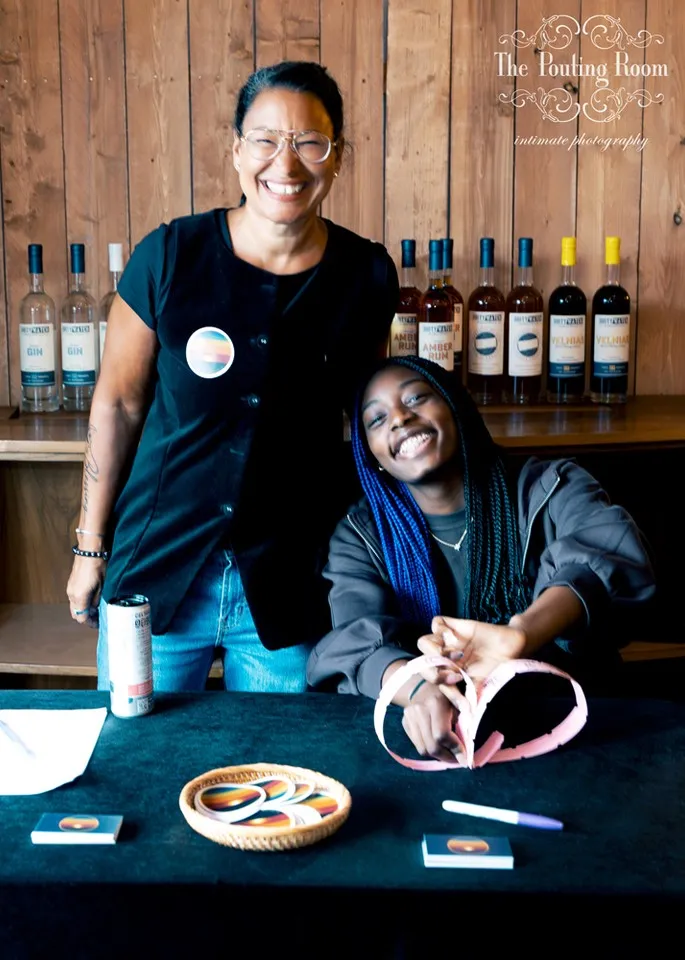 Two volunteers laughing behind the welcome table at Dirty Tea