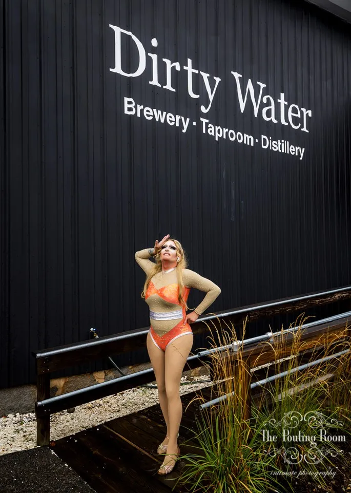 A drag performer under the Dirty Water Brewery, Taproom and Distillery sign