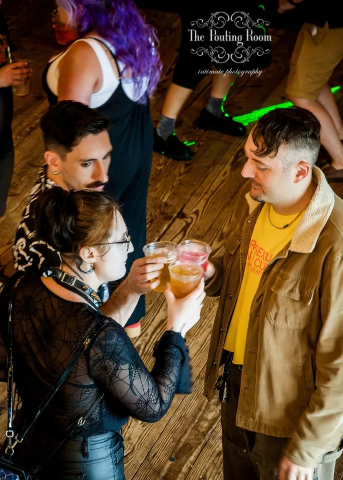 Three guests toasting their drinks together at Dirty Tea