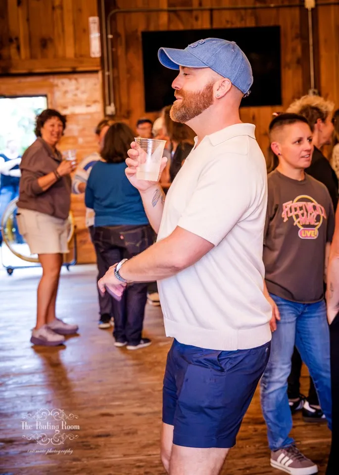 A guest dancing with a drink in hand in the crowd at Dirty Tea