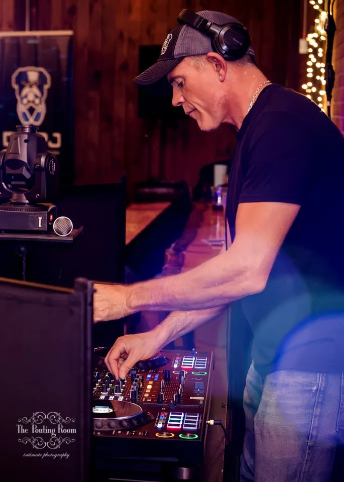 The DJ mixing in headphones at the decks during Dirty Tea