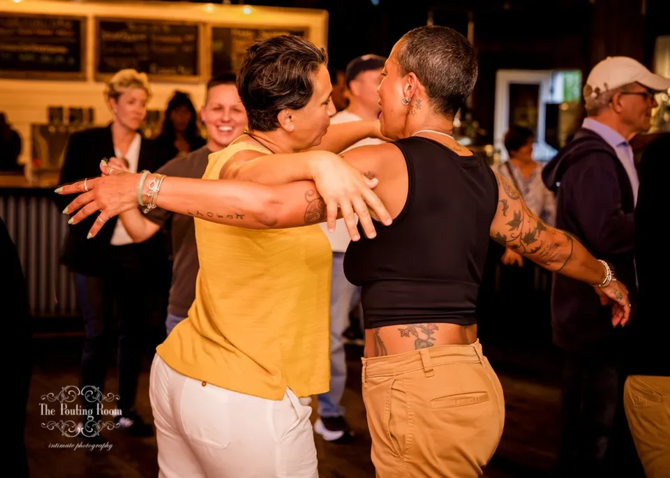 Two guests dancing arm in arm in the middle of the crowd at Dirty Tea