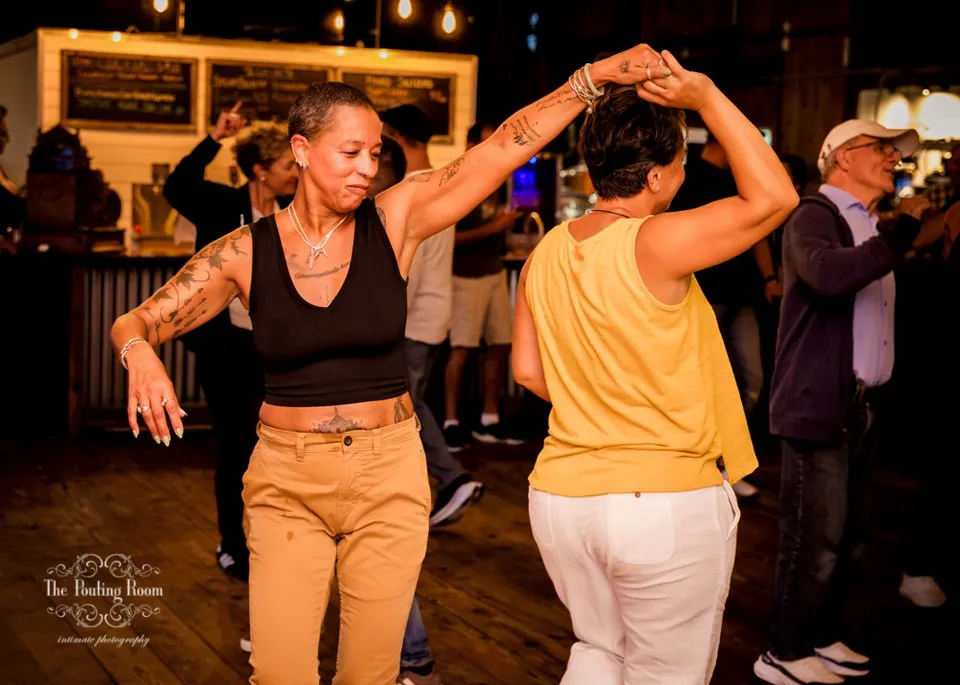 A dancer spinning her partner under her arm at Dirty Tea