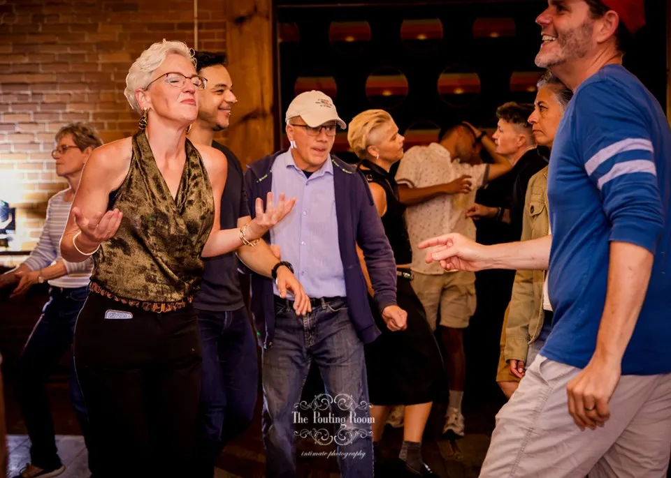 A row of guests dancing together under the brick arches at Dirty Tea
