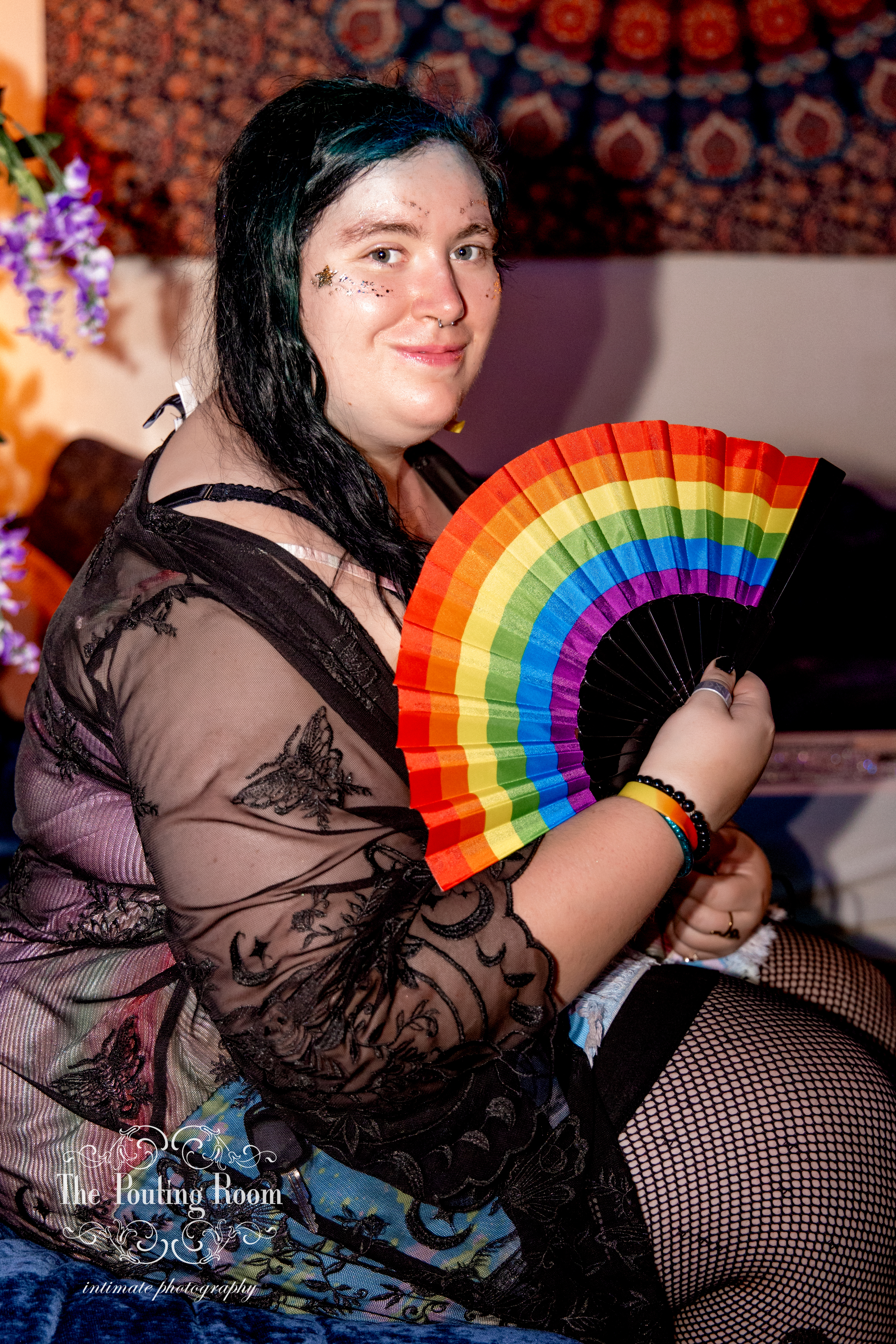 A guest posing with a rainbow Pride fan